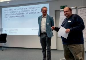 Lutz Lašewski wót Serbskego instituta prezentěrujo referěrujucego kolegu Europskego centruma za mjeńšynowe temy Martina Klatta na lipšćańskej konferency MINREG 2025. Foto: Měto Nowak