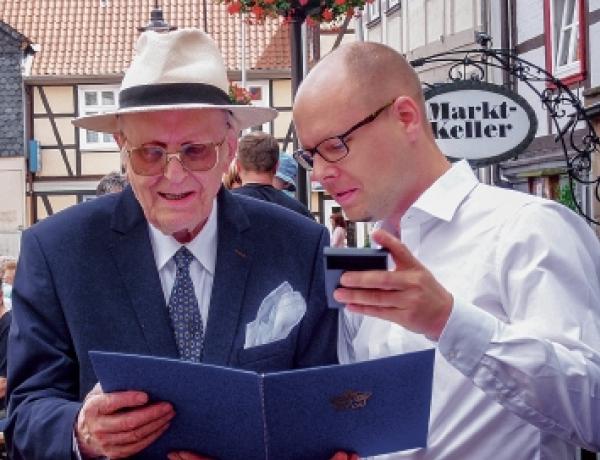 Dr. Kowalewski z předsydu Domowiny w lěće 2015 na měšćanskim swjedźenju we Łuchowje (Lüchow) po tym, zo je z rukow Statnika jako wuznamjenjenje za swoje dołholětne skutkowanje na dobro poćahow mjez Wendlandom a Serbami slěbornak «Dudak» z wopismom dóstał. Foto: Werner Sroka